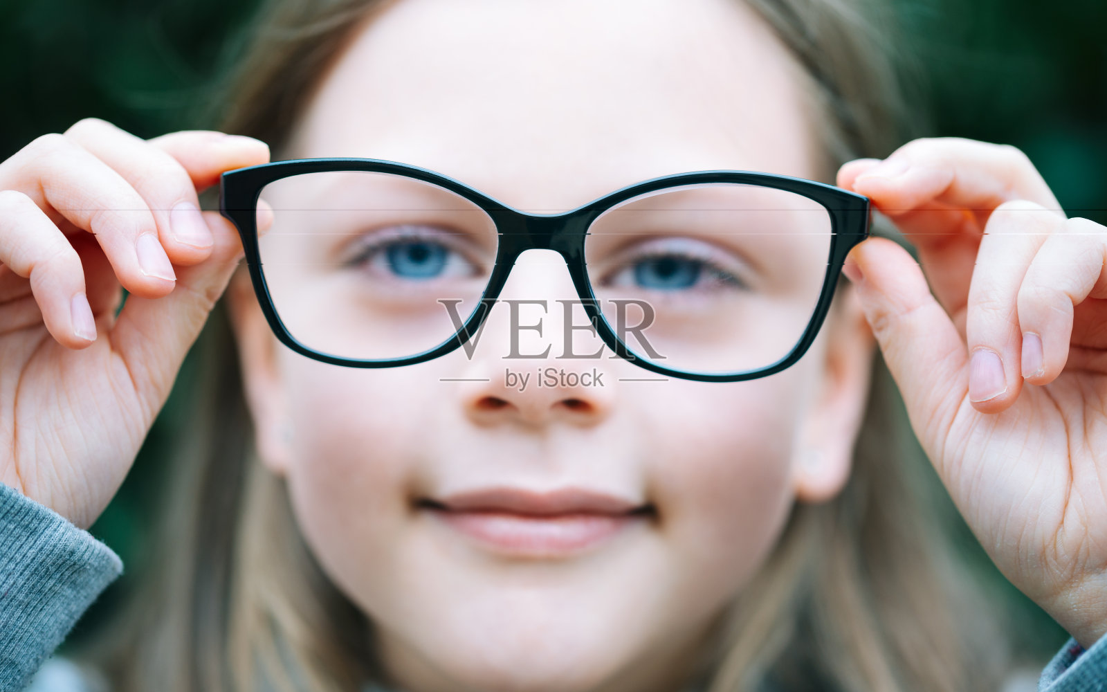 小女孩的特写肖像与近视矫正眼镜照片摄影图片