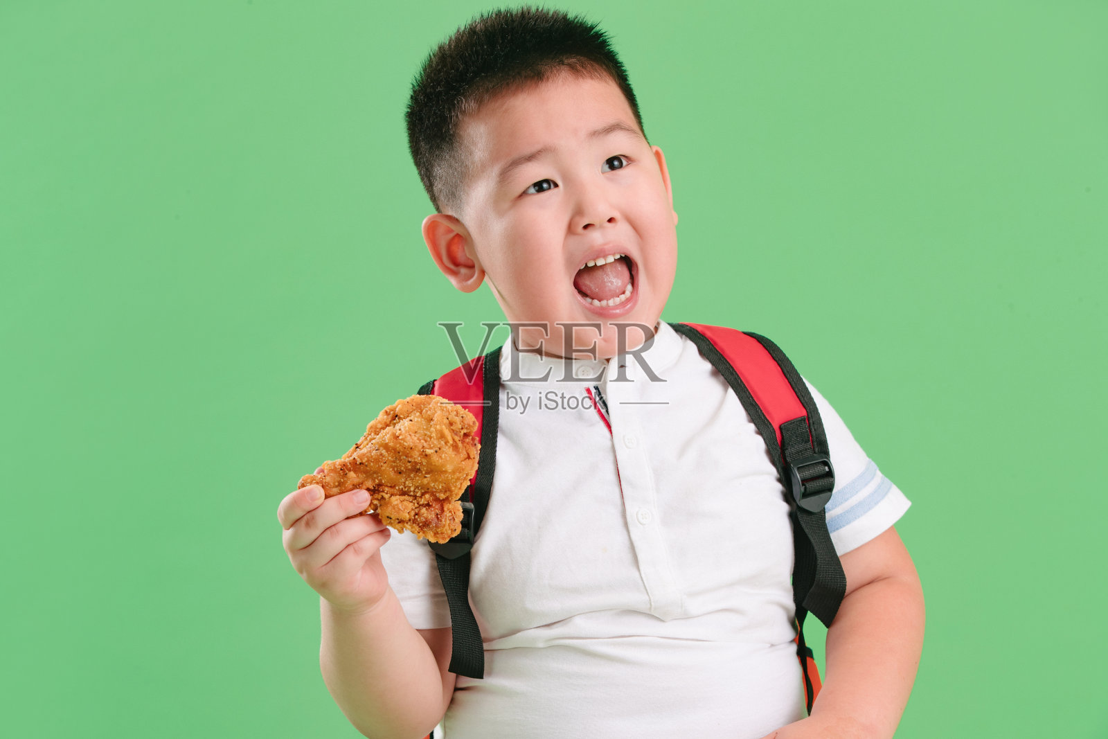 可爱的小男孩吃炸鸡照片摄影图片