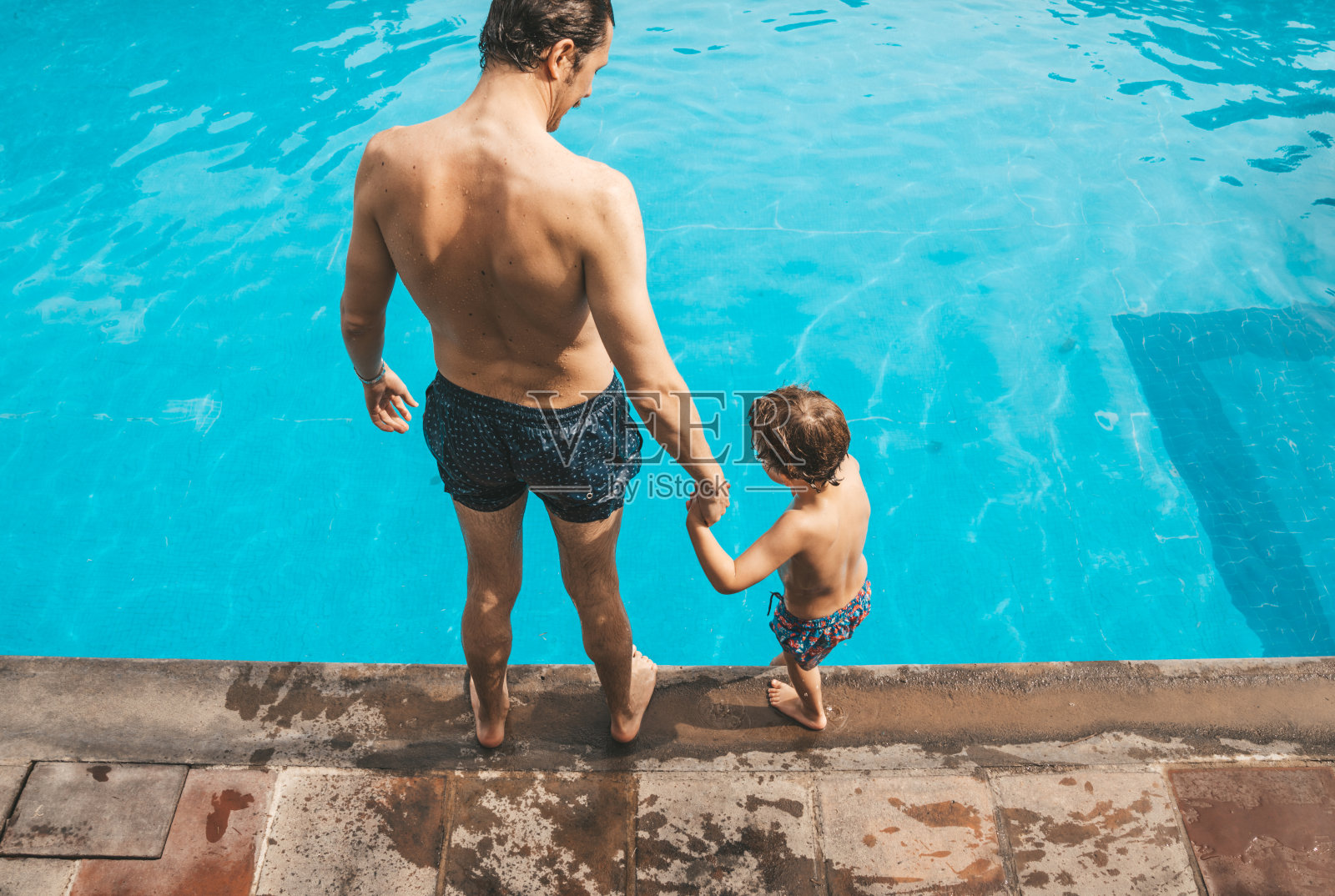 爸爸和儿子在游泳池里玩照片摄影图片