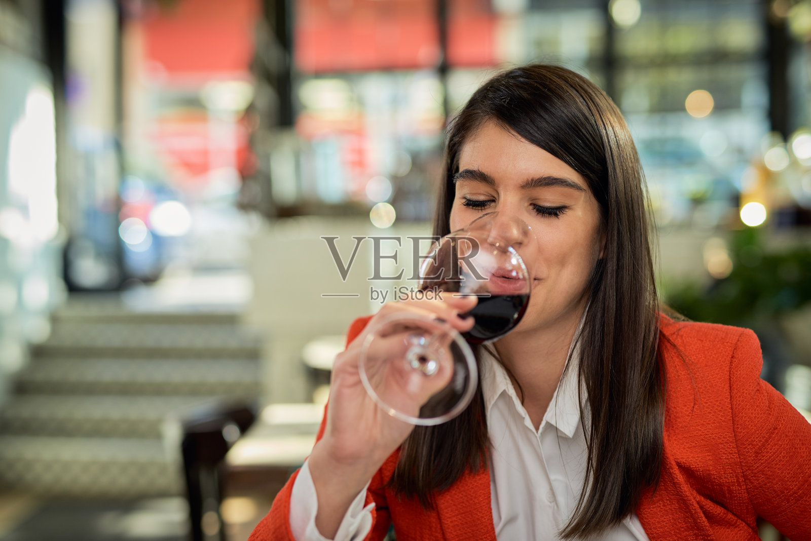 画像美丽的白人深色西装坐在餐厅喝红酒。照片摄影图片