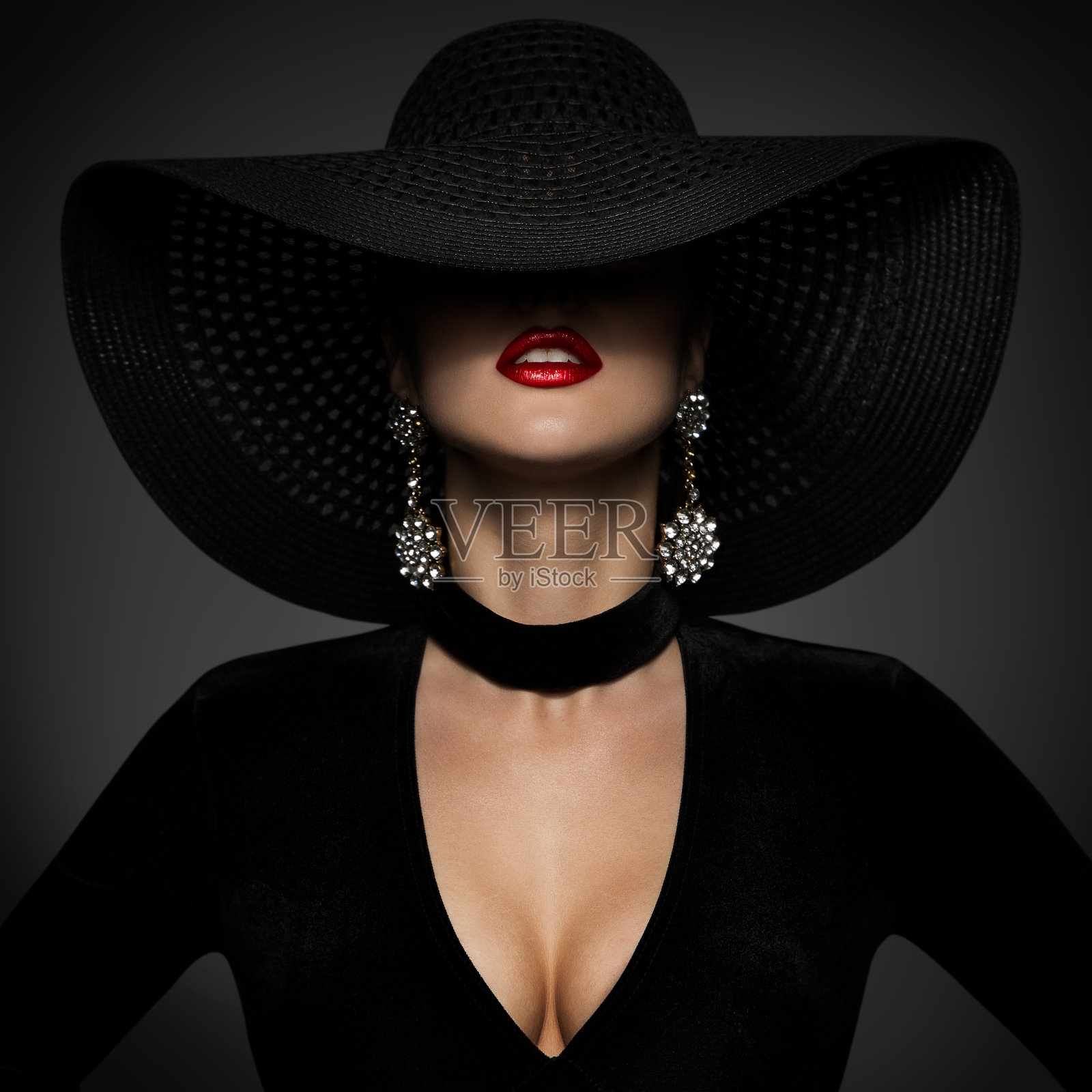时尚模特在性感的黑色连衣裙，优雅的女人美丽在宽宽的边缘帽覆盖的脸照片摄影图片
