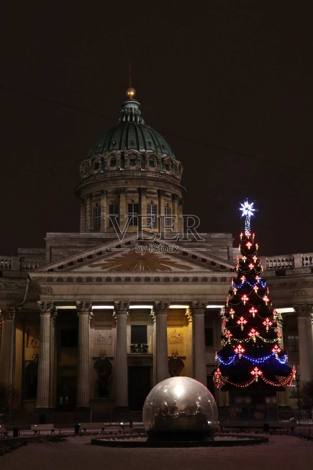 广场上的圣诞树上挂着彩灯，大教堂在晚上用胶布装饰照片摄影图片