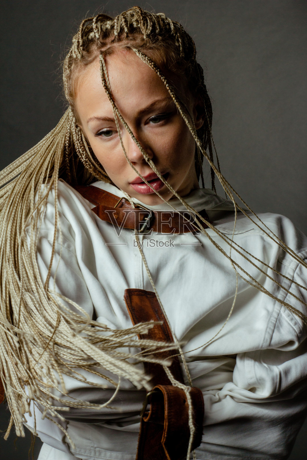 用Zizi的技术描绘了一个有创意的发型的非洲辫子的女人。穿紧身衣的女孩。精神障碍，创伤的概念。照片摄影图片