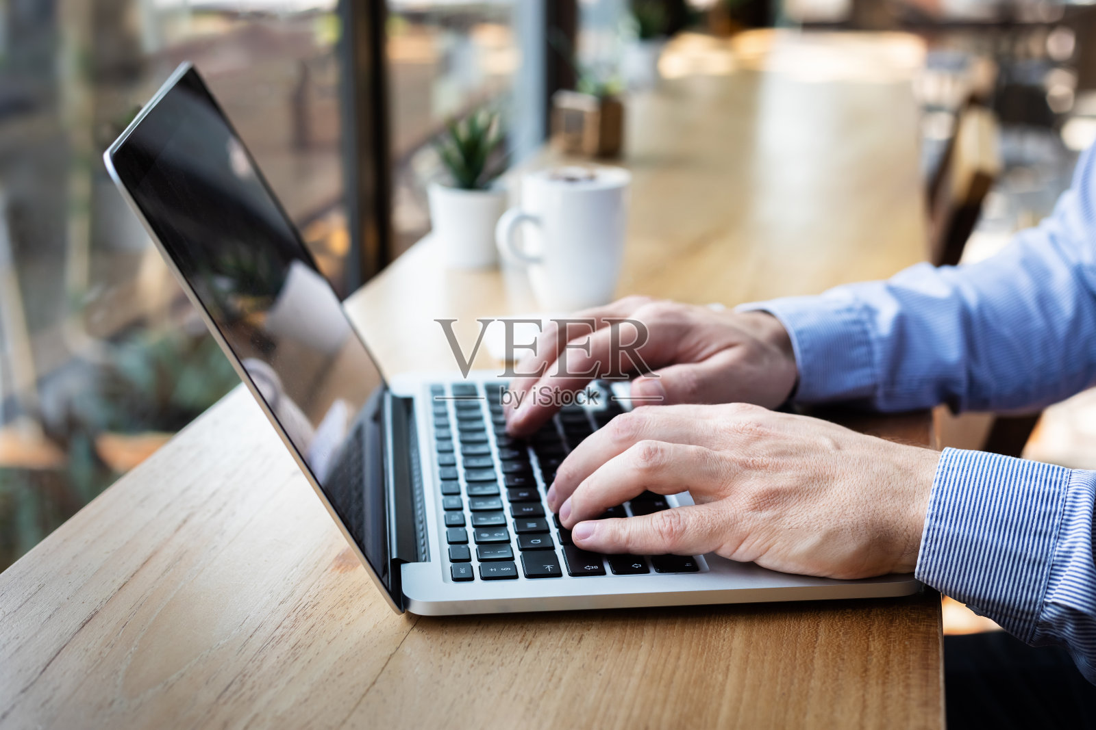 手在笔记本电脑键盘上打字，人写电子邮件或报告文件在咖啡馆有咖啡和wifi网络，休闲风格，拷贝空间照片摄影图片
