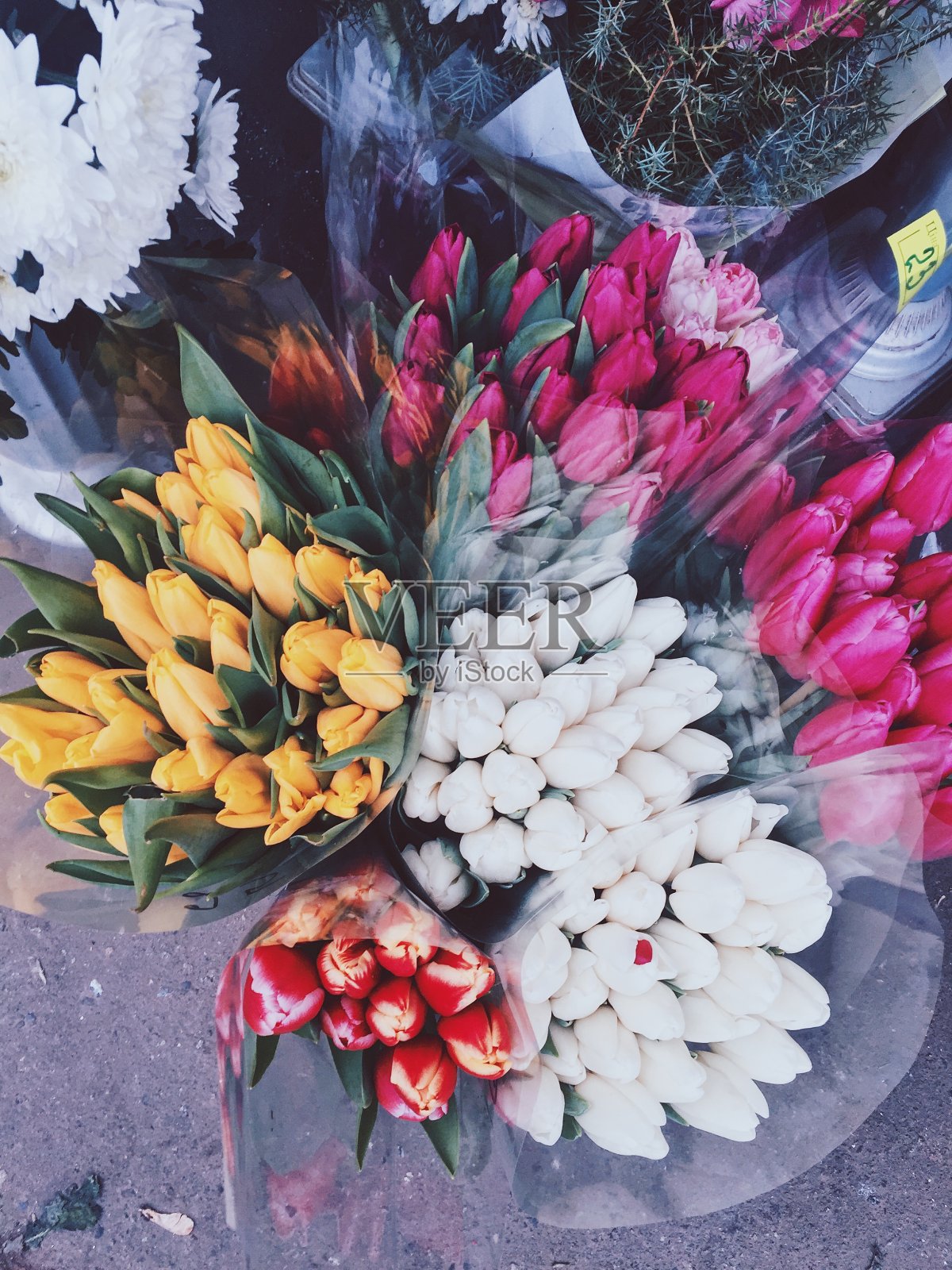 3月8日给女孩和妈妈们的礼物。市场上的郁金香花束。五颜六色的鲜花照片摄影图片