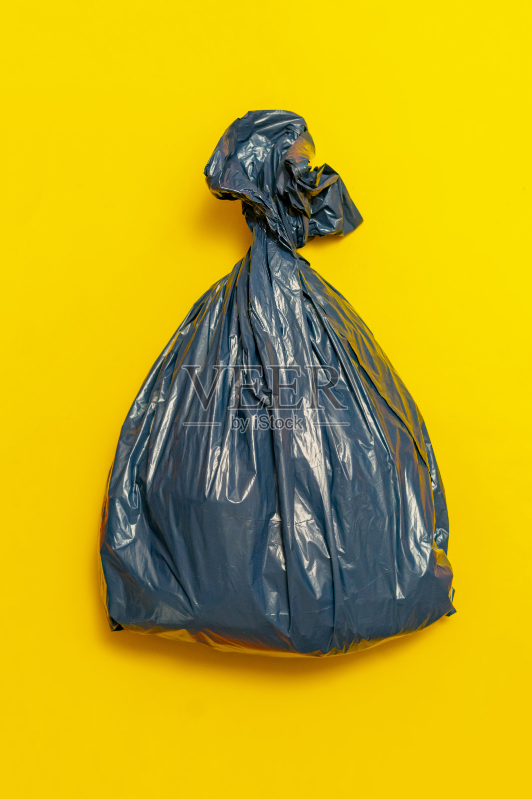 装满垃圾的塑料垃圾袋在五彩缤纷的背景下孤立起来，照片摄影图片