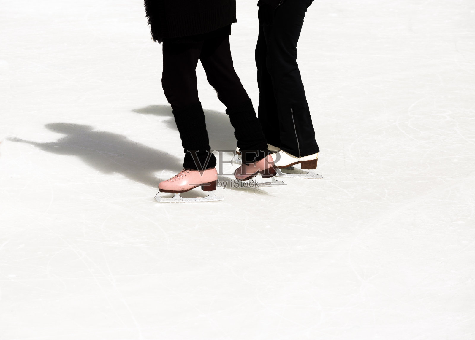 冬日里，两个十几岁的女孩在冰上滑冰照片摄影图片