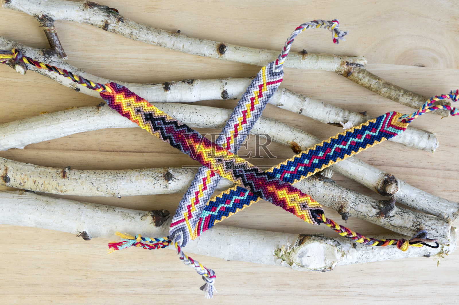 一组简单手工自制的友谊天然编织手链，以木制为背景，彩虹色，格子图案照片摄影图片