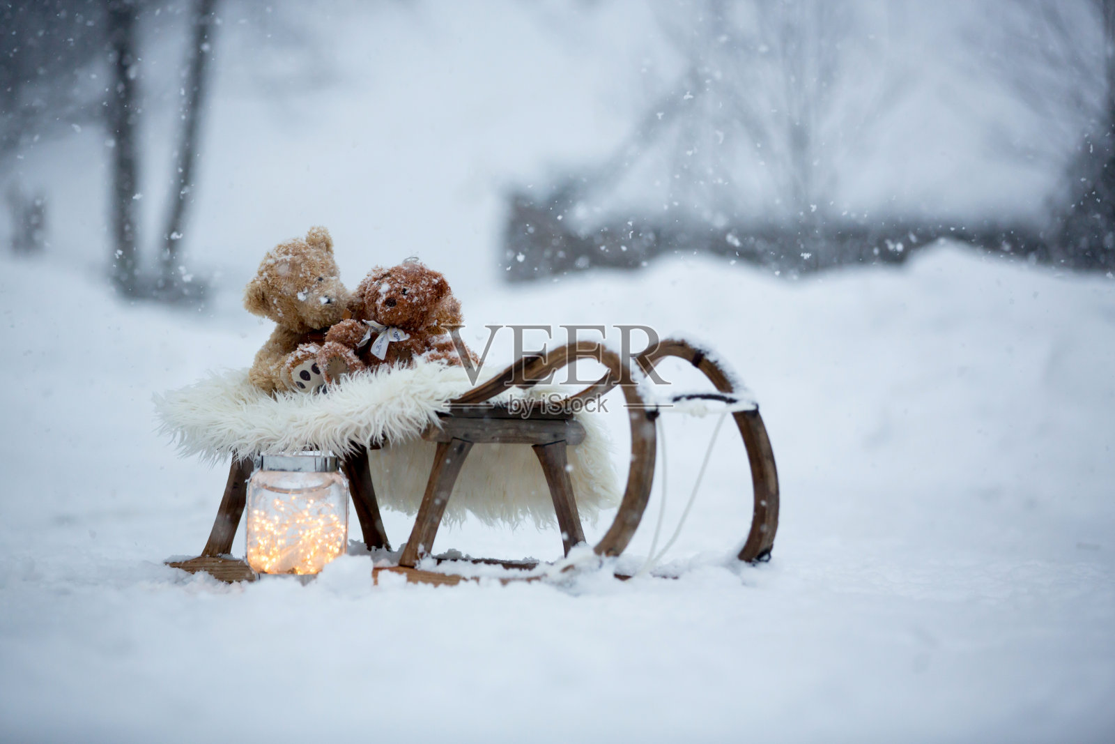 泰迪熊在雪地里，冬天的时候。小孩子在下雪天玩玩具照片摄影图片