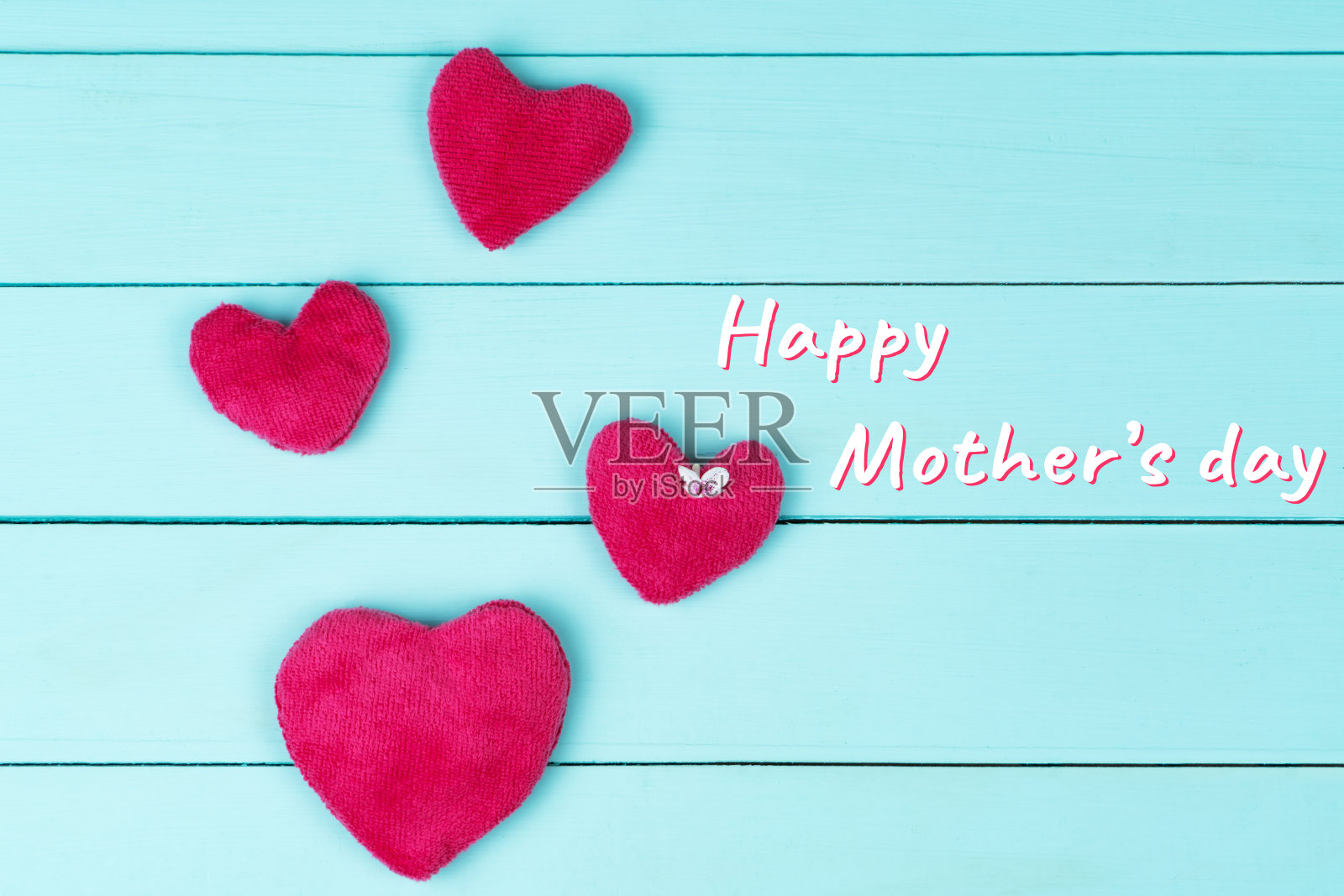 母亲节，在蓝色的木质背景上开着粉红色的心小花照片摄影图片