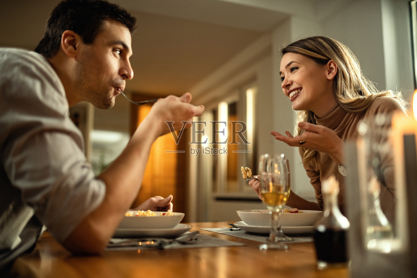 下面是一对幸福的夫妇在餐桌上聊天。照片摄影图片