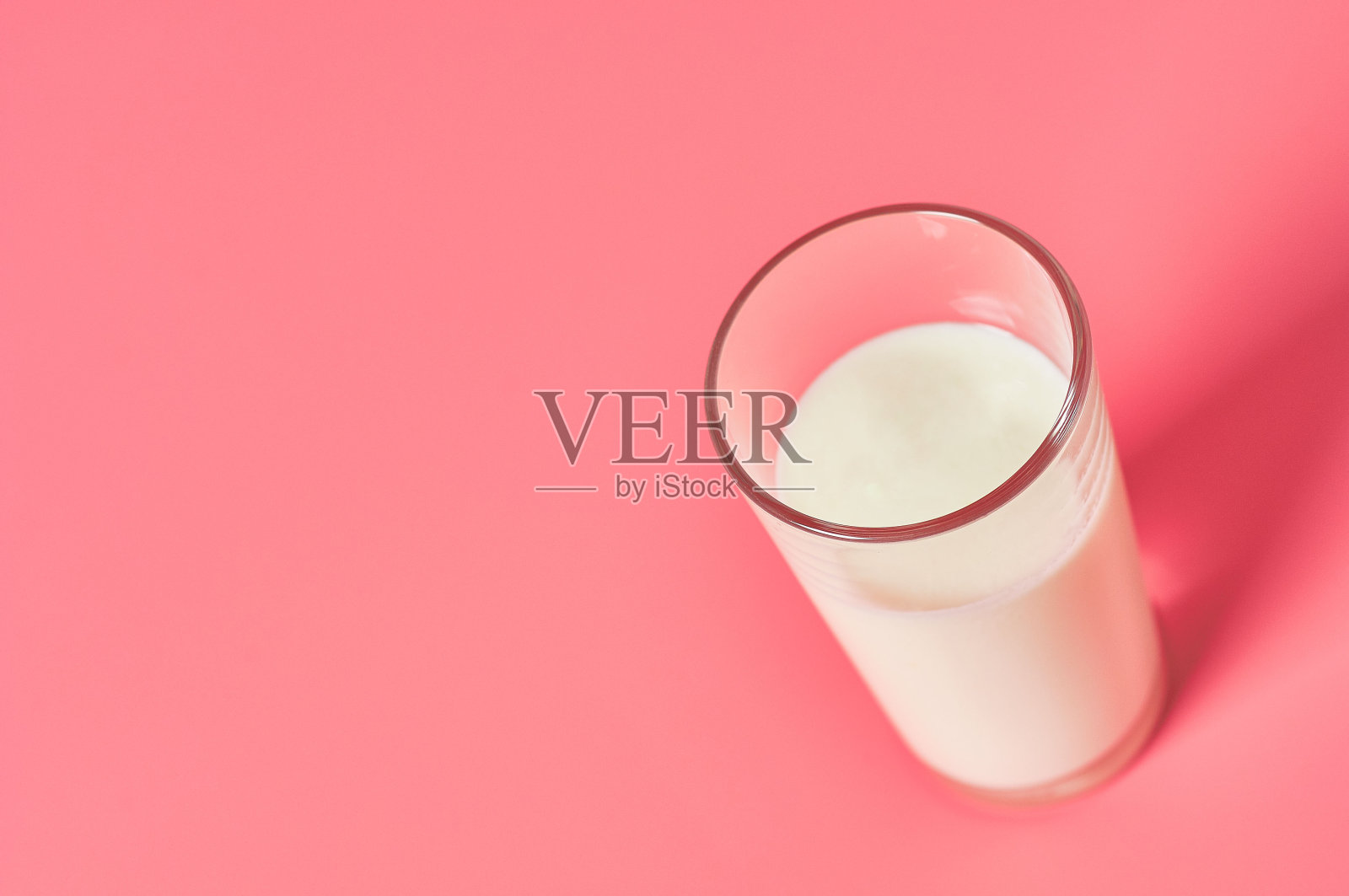 满杯鲜奶，粉色背景。空间的文本照片摄影图片