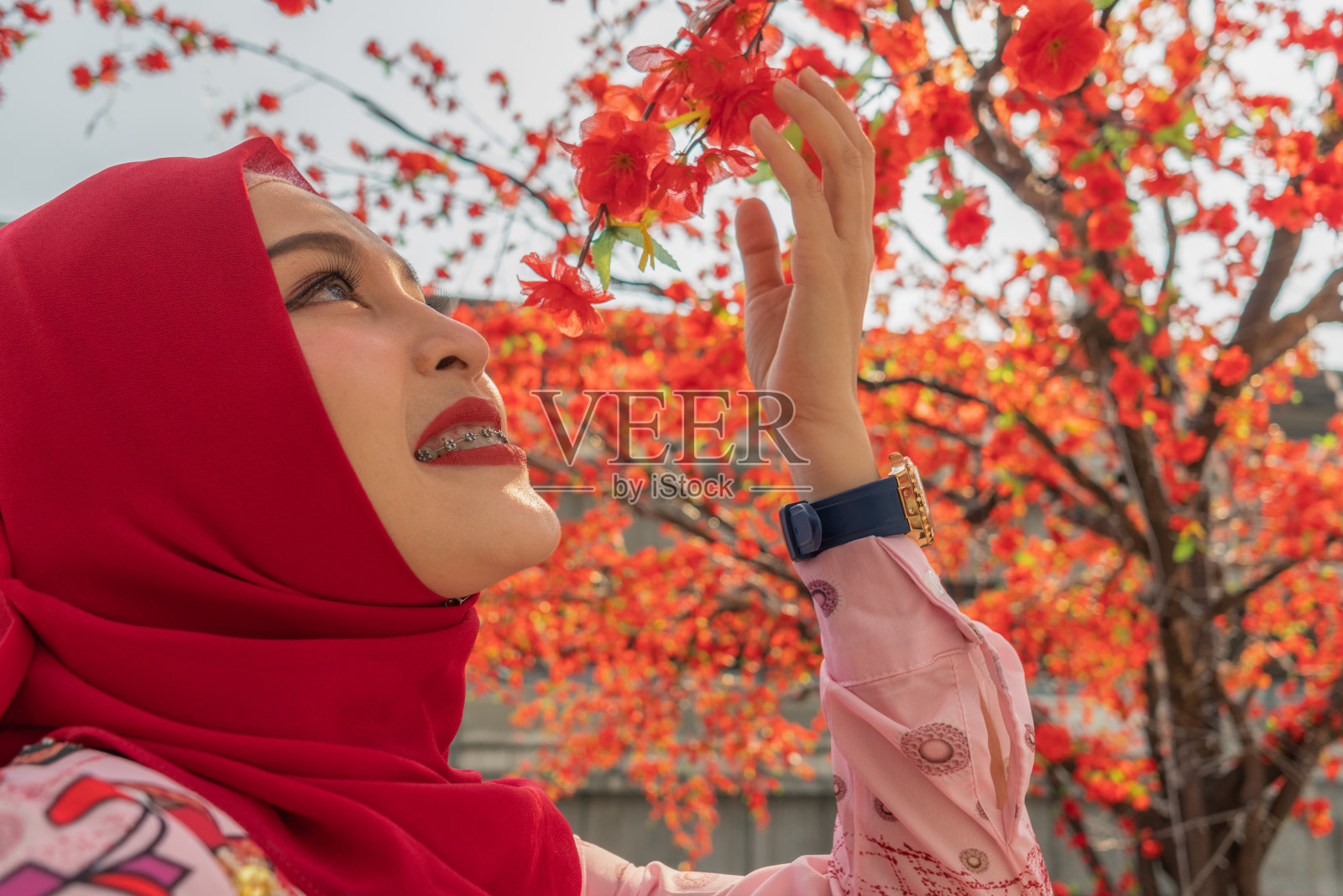 美丽的伊斯兰女士喜欢与红色樱花照片摄影图片