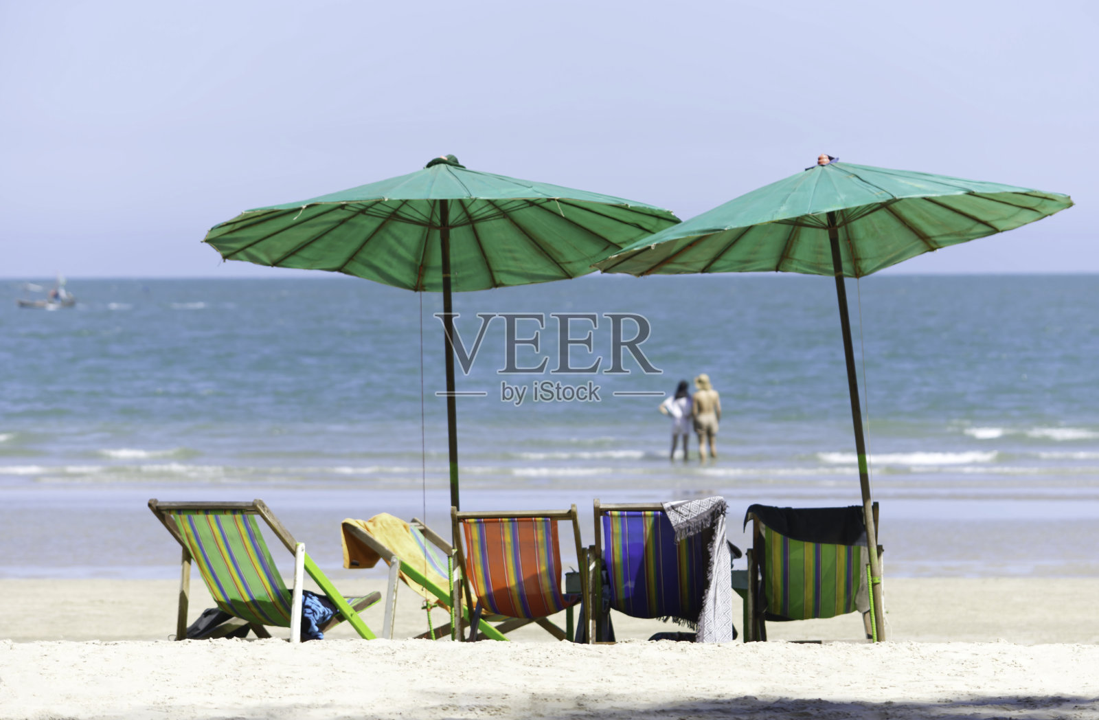 沙滩上的帆布床和雨伞背景模糊旅游和大海。照片摄影图片