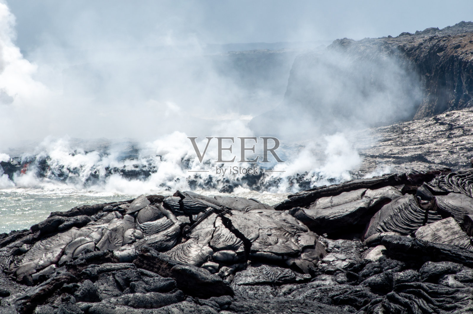 位于夏威夷的火山国家公园，可以看到熔岩和水照片摄影图片