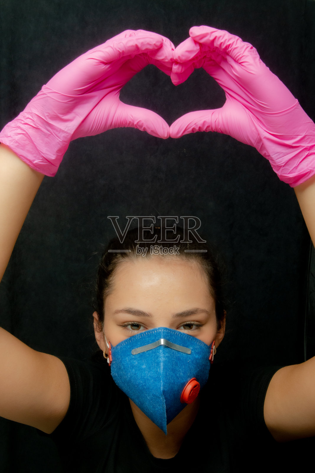 女孩用口罩和手套做一个心形标志-冠状病毒-冠状病毒19照片摄影图片