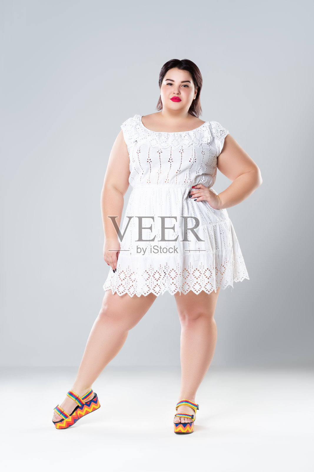 加码时装模特在白色的裙子，胖女人在灰色的背景，身体积极的概念照片摄影图片