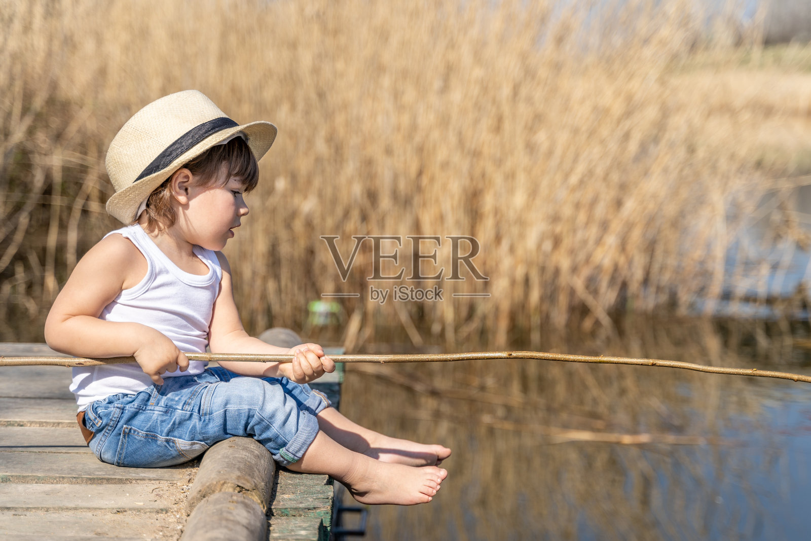 小渔夫在河边钓鱼照片摄影图片