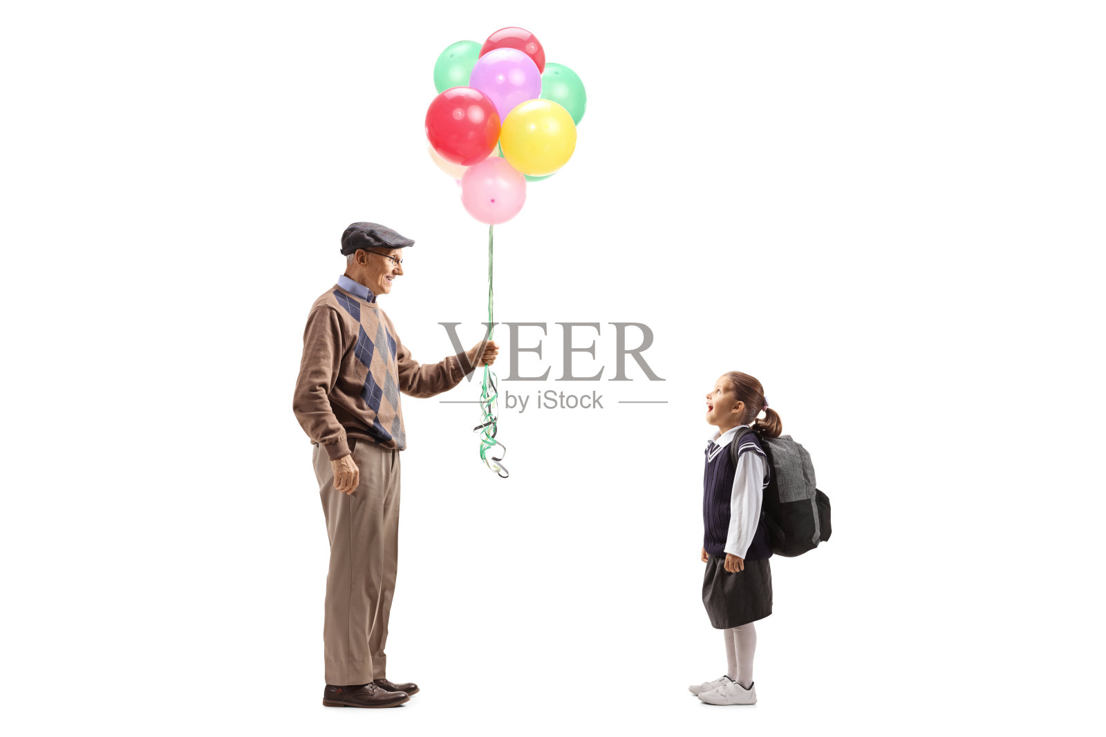 一位老人把彩色气球送给一位兴奋的女学生照片摄影图片