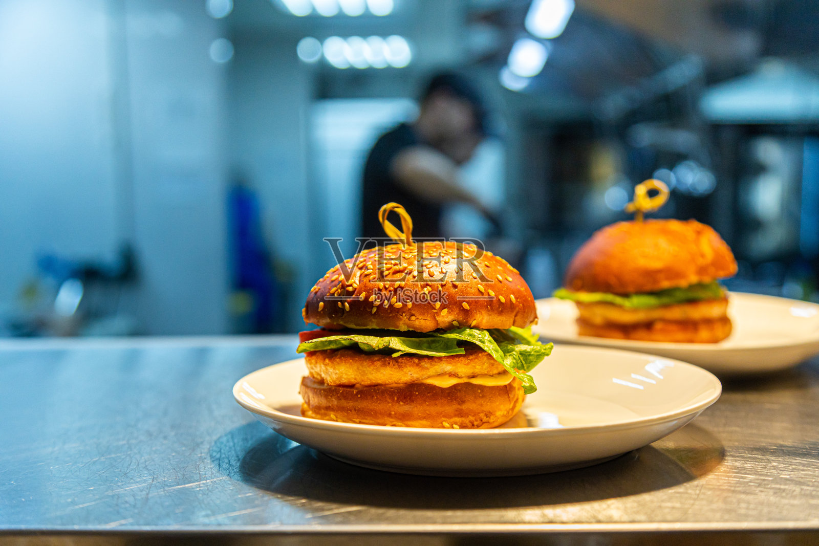 背景是餐厅和厨房柜台上供服务员享用的速食汉堡照片摄影图片
