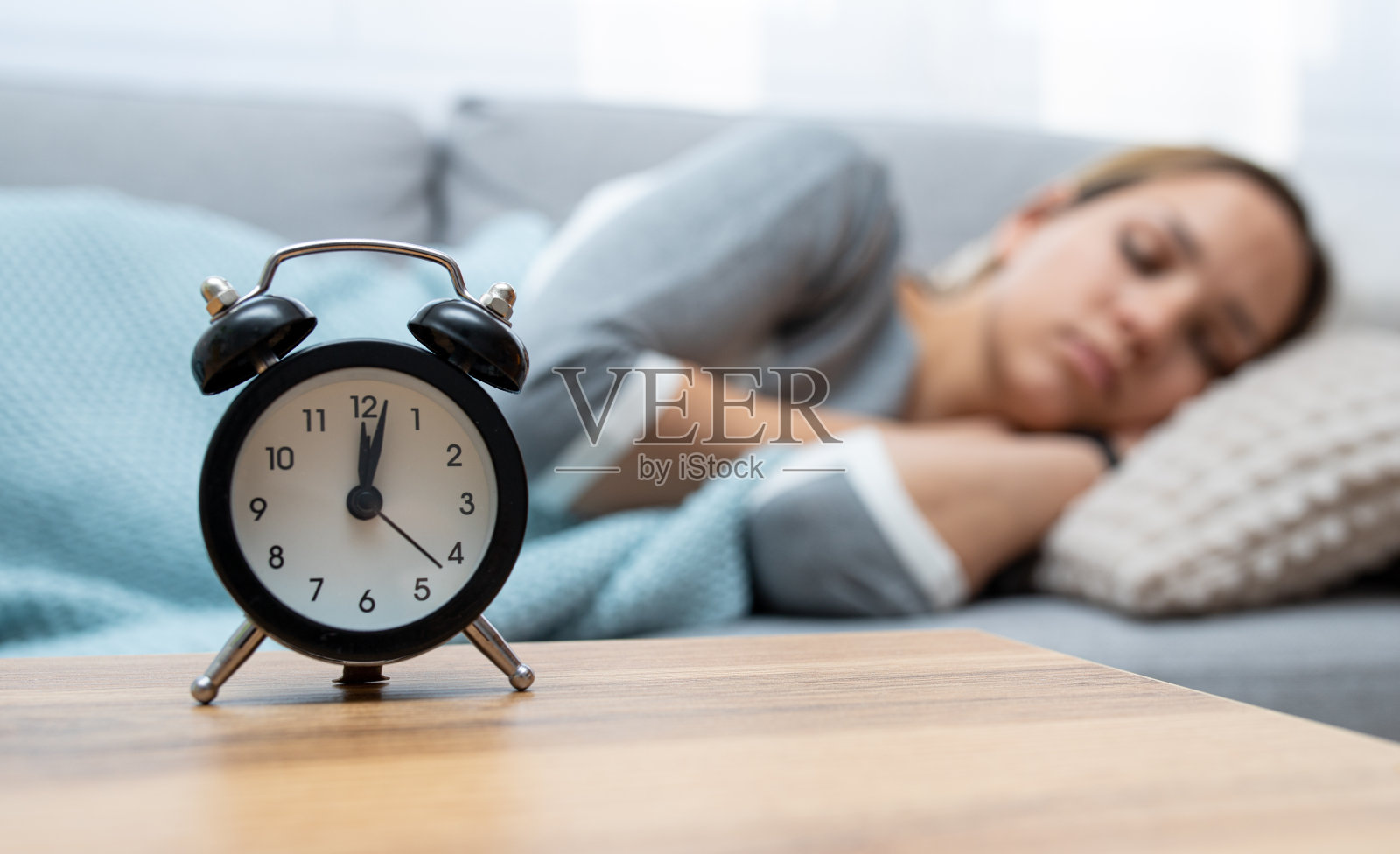 女人平静地睡着。闹钟在熟睡的女人面前照片摄影图片