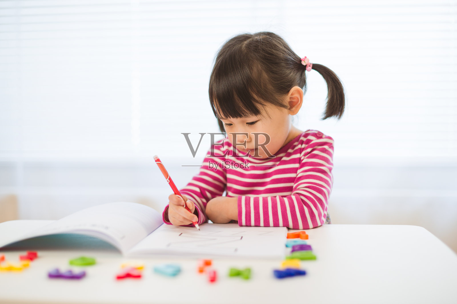 蹒跚学步的小女孩练习在家学习写信照片摄影图片