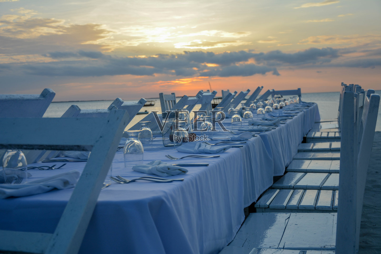 日落时分在海滩上用餐的优雅餐桌照片摄影图片