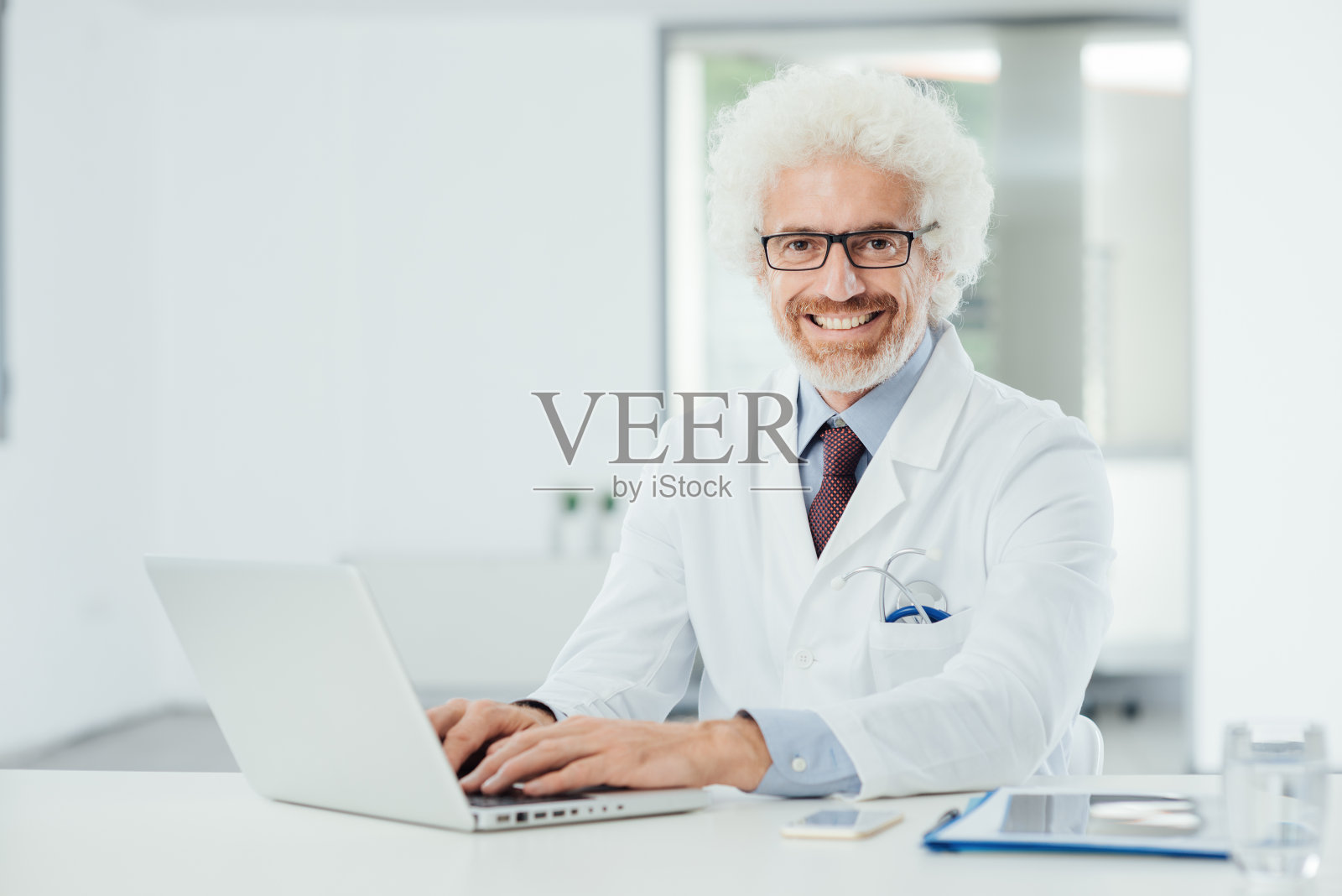 微笑的医生在办公桌上工作照片摄影图片