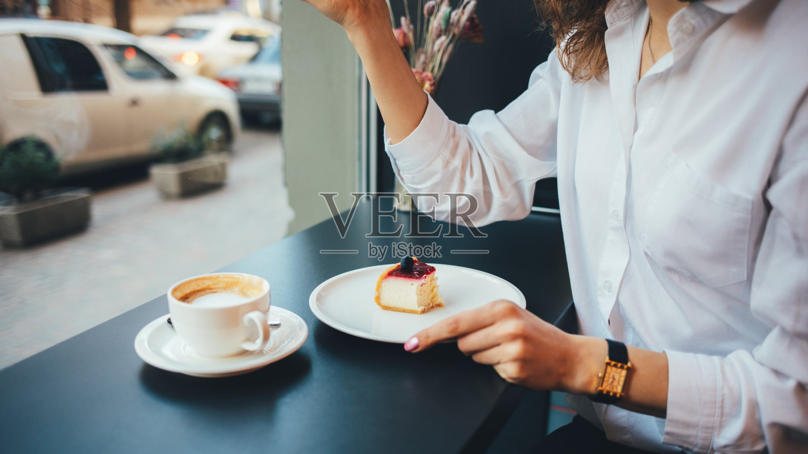 年轻女子吃着芝士蛋糕喝着咖啡照片摄影图片