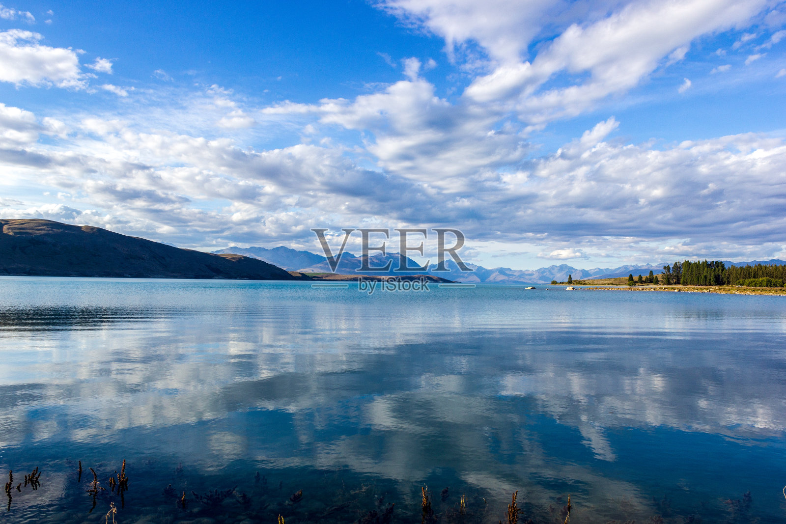 美丽的特卡波湖与山脉在一个阳光明媚的日子与云，新西兰南岛照片摄影图片