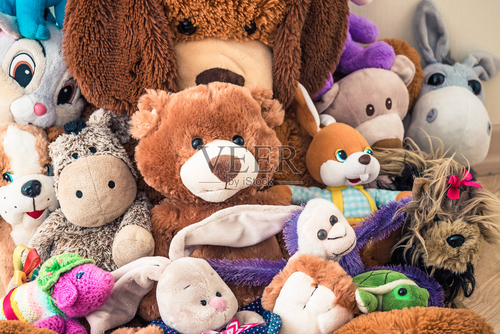 许多柔软的毛绒玩具坐在孩子们的房间的地板上照片摄影图片