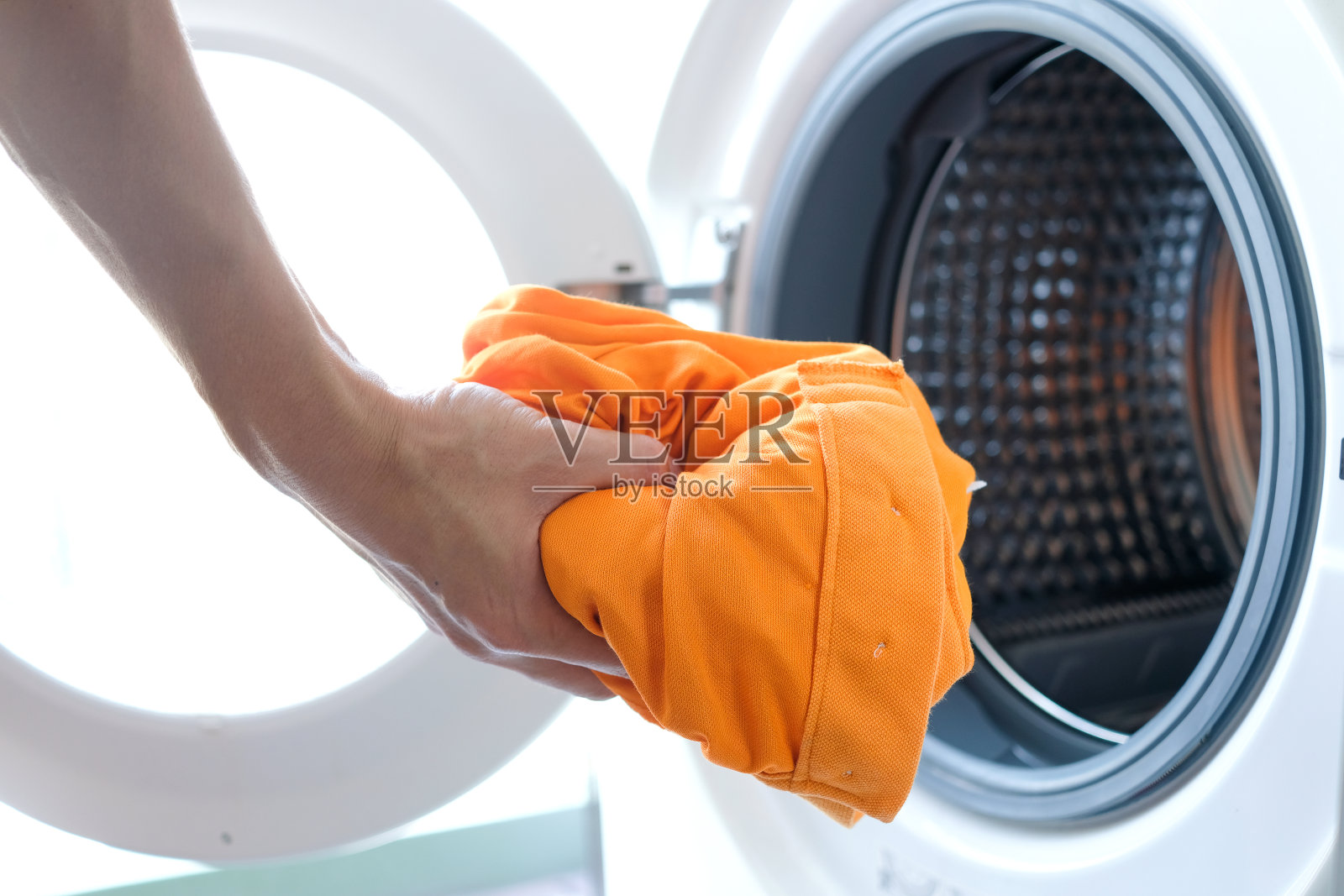 女人的手拿衣服洗衣机。清洁健康的概念照片摄影图片