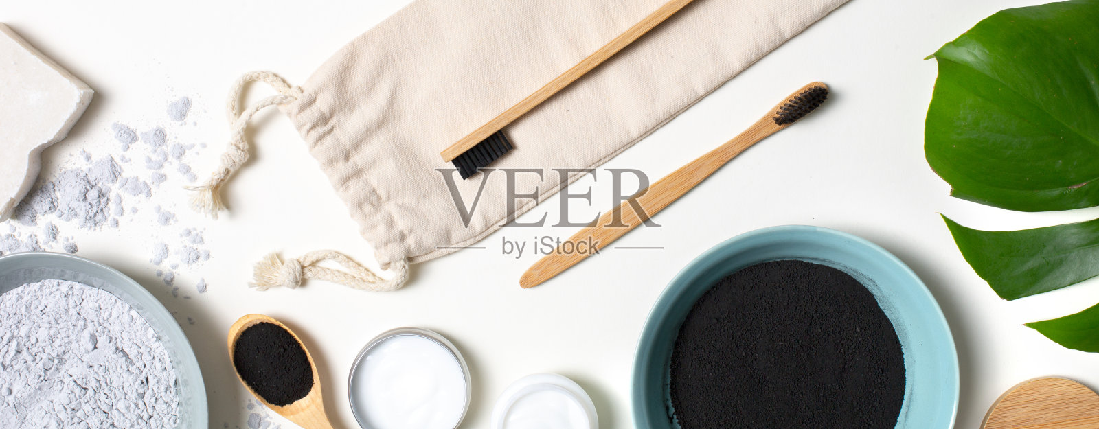 扁平的竹制牙刷，黑色尼龙刷毛，黑色木炭膏，粉末和天然化妆品照片摄影图片