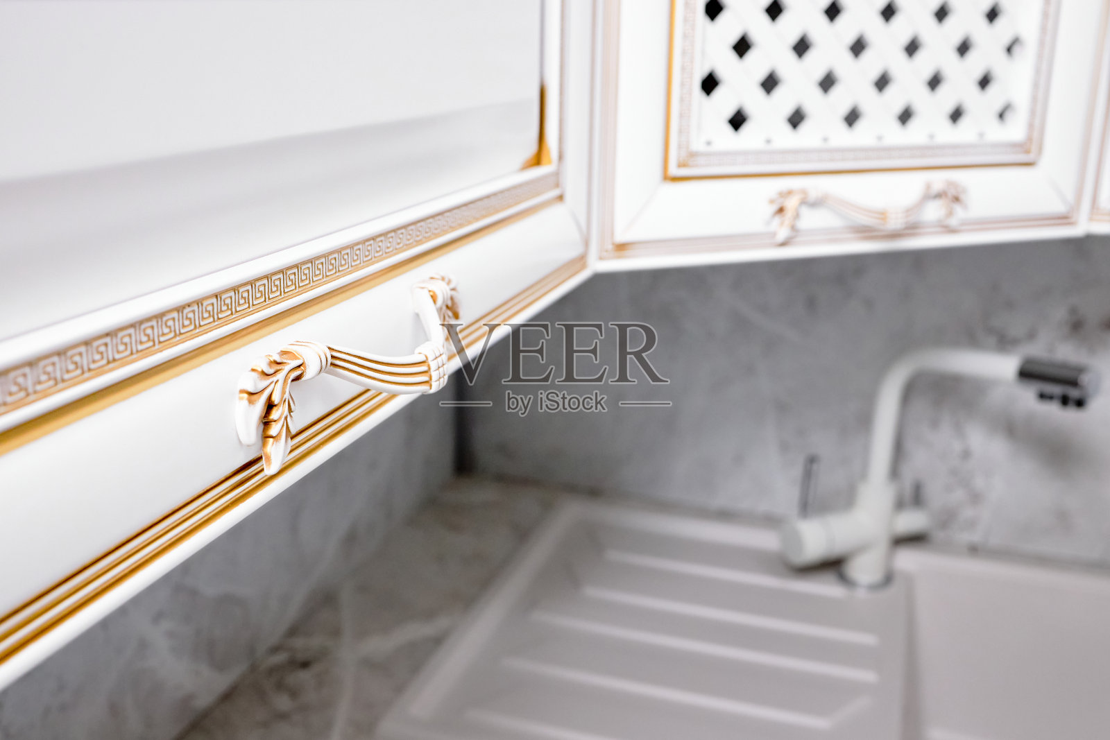 门把手家具概念。厨房立面面板装饰元素白色木质橱柜或橱柜旋钮，白色和金色的古希腊装饰边框装饰图案。照片摄影图片