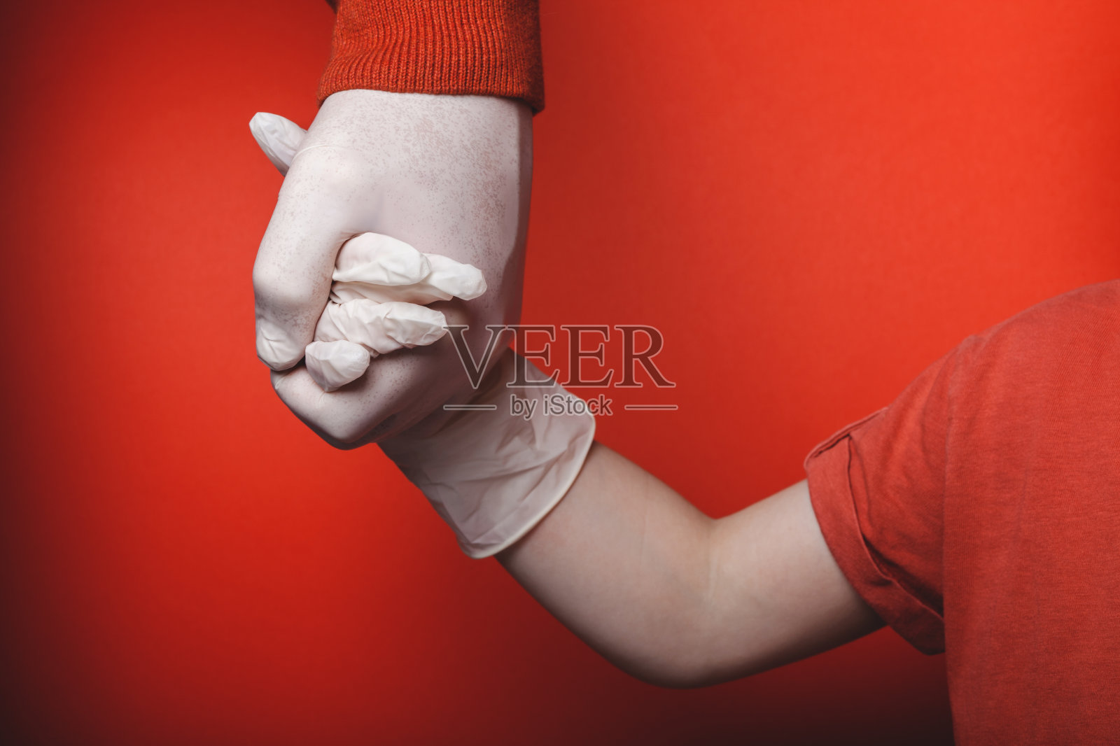 爸爸和儿子手牵着手，戴着一次性医用手套。照片摄影图片