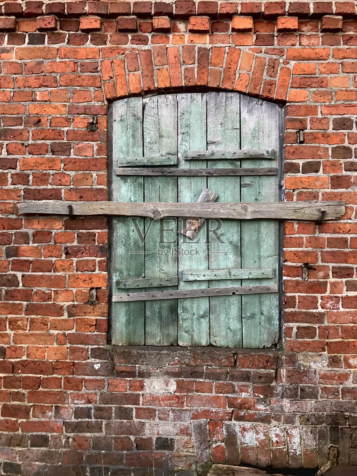 带有木制百叶窗的旧砖墙。这是一座建于1850年的房子的墙。照片摄影图片