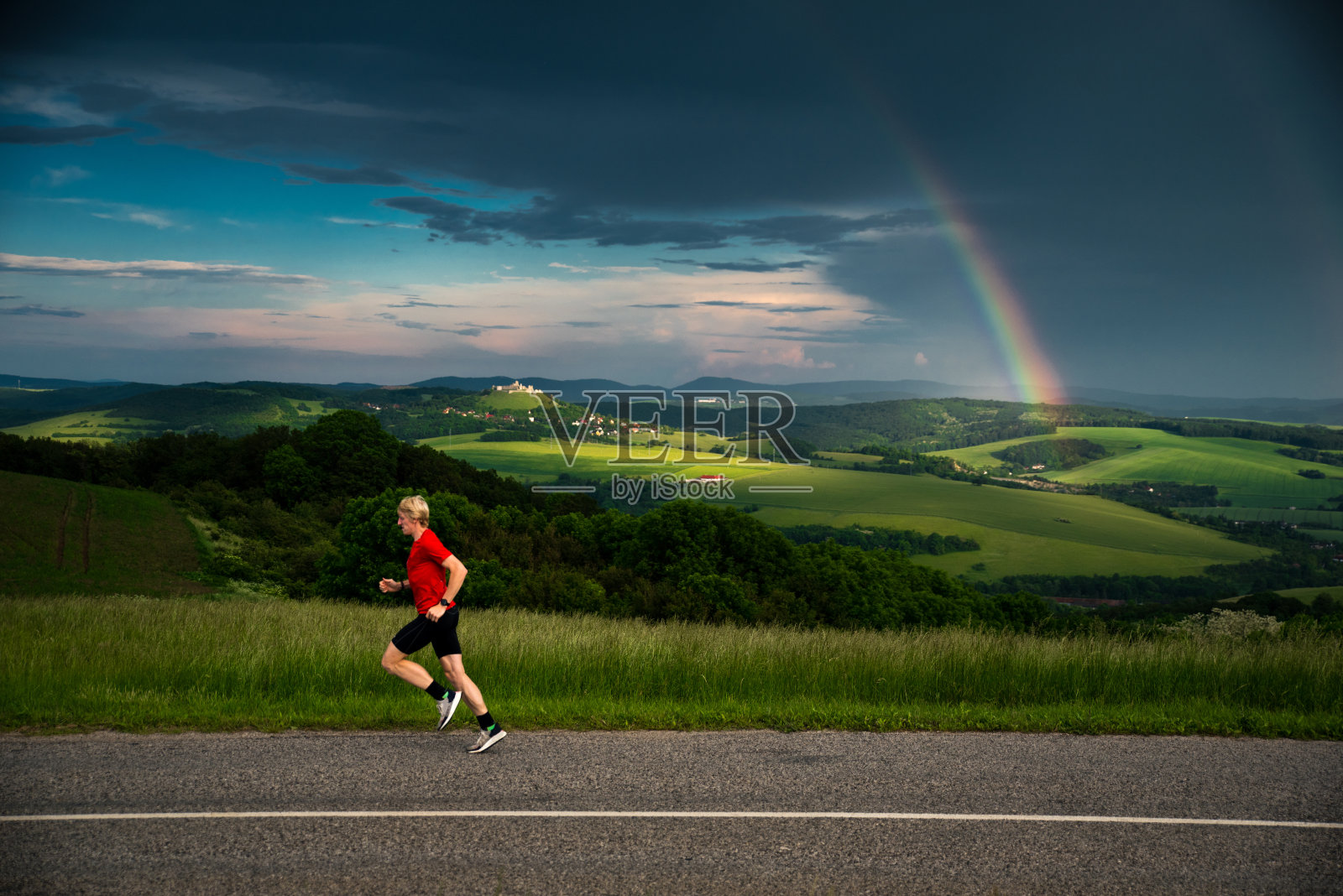 人在美丽的大自然中奔跑，在夏日的绿水景观中训练，在彩虹和田园风光的背景中训练照片摄影图片