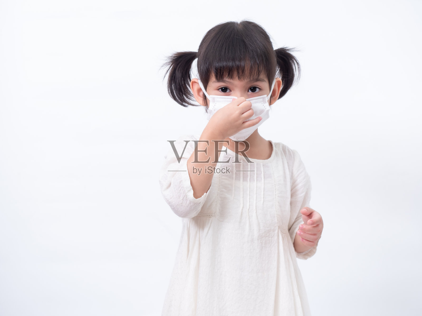 亚洲可爱的小女孩4岁戴一个卫生口罩，以保护传播疾病的白色背景。预防新冠肺炎感冒或污染的传播。照片摄影图片