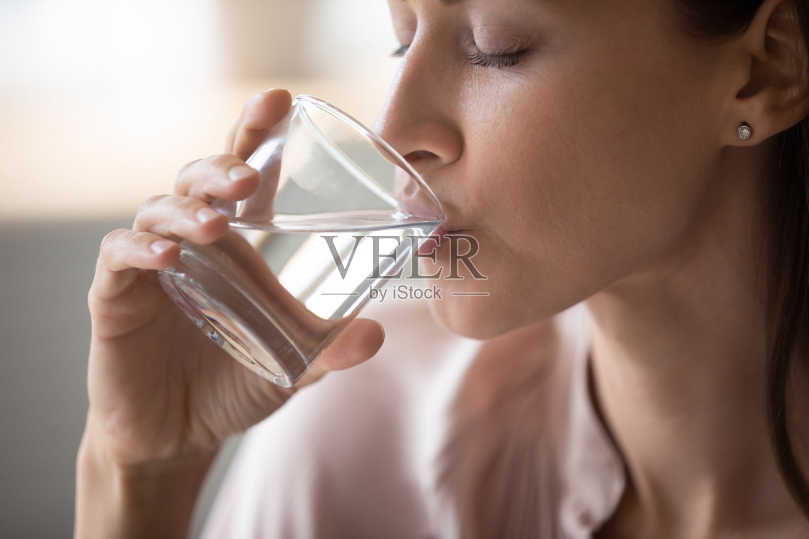 年轻女子早上喝纯净水。照片摄影图片