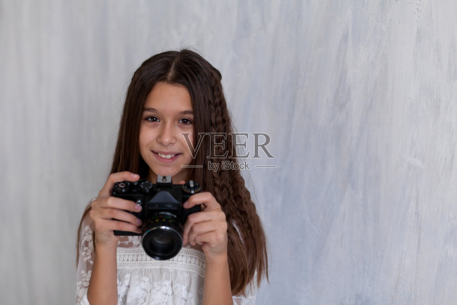 一个带着相机的女学生摄影师的肖像照片摄影图片