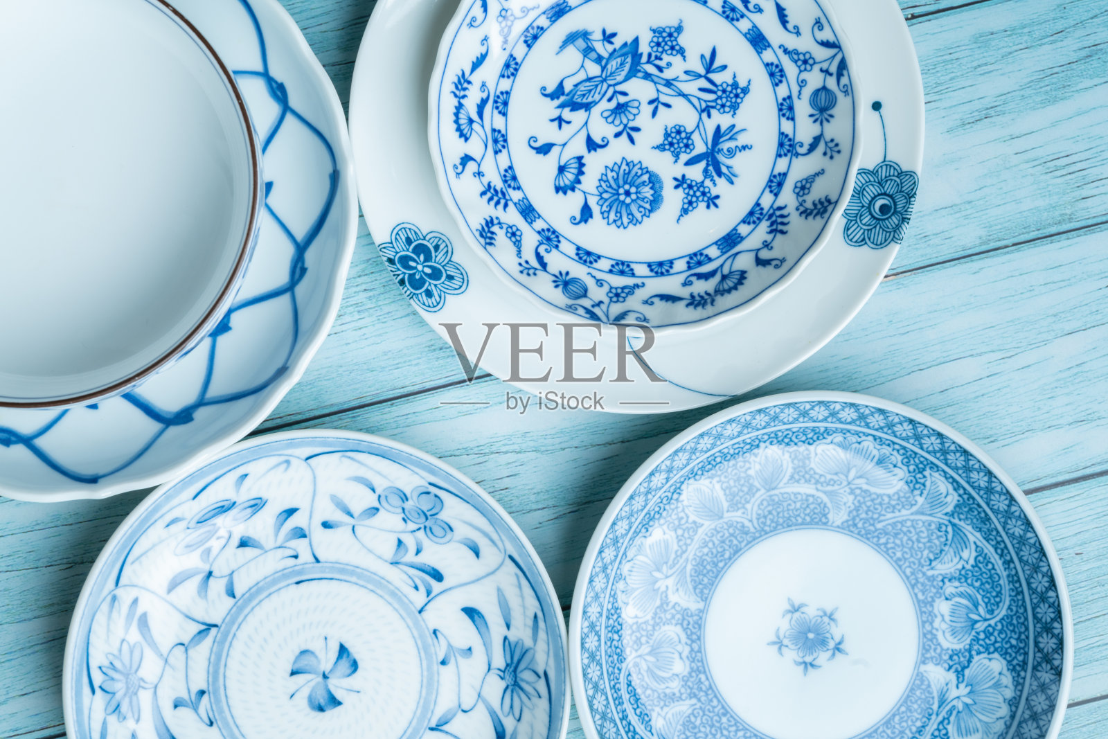 以质朴的蓝色木材为背景，带有蓝色图案的陶瓷盘子照片摄影图片