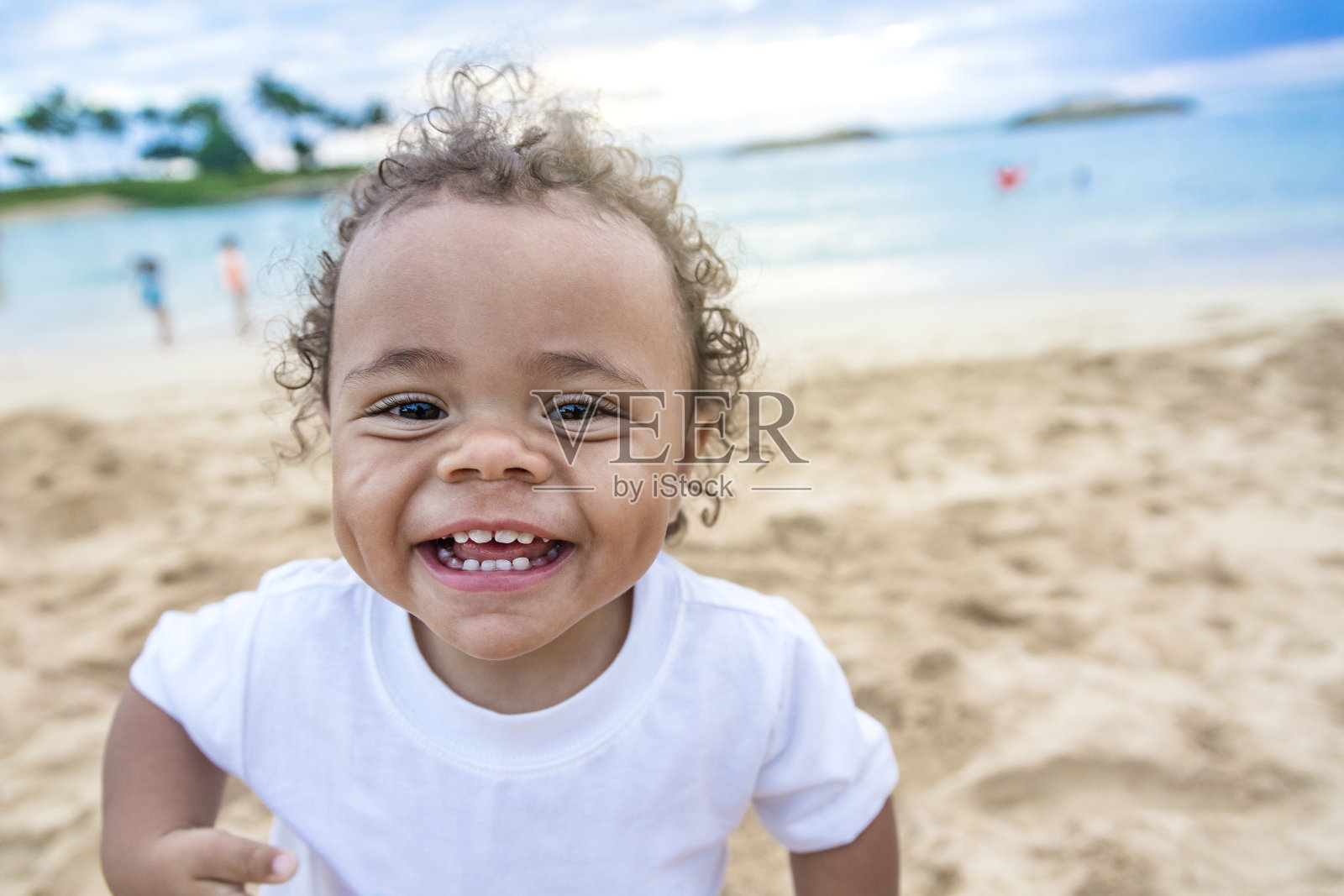 可爱微笑的混血小男孩在海滩上玩耍照片摄影图片