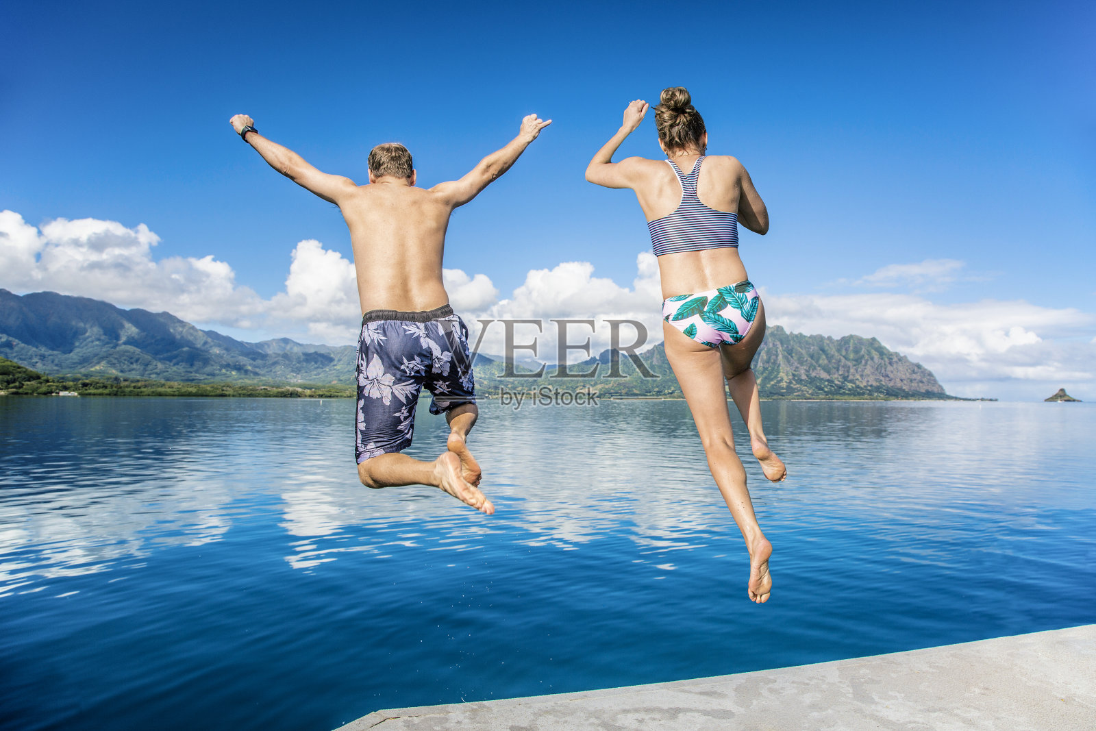 人们在夏威夷度假时跳入大海照片摄影图片