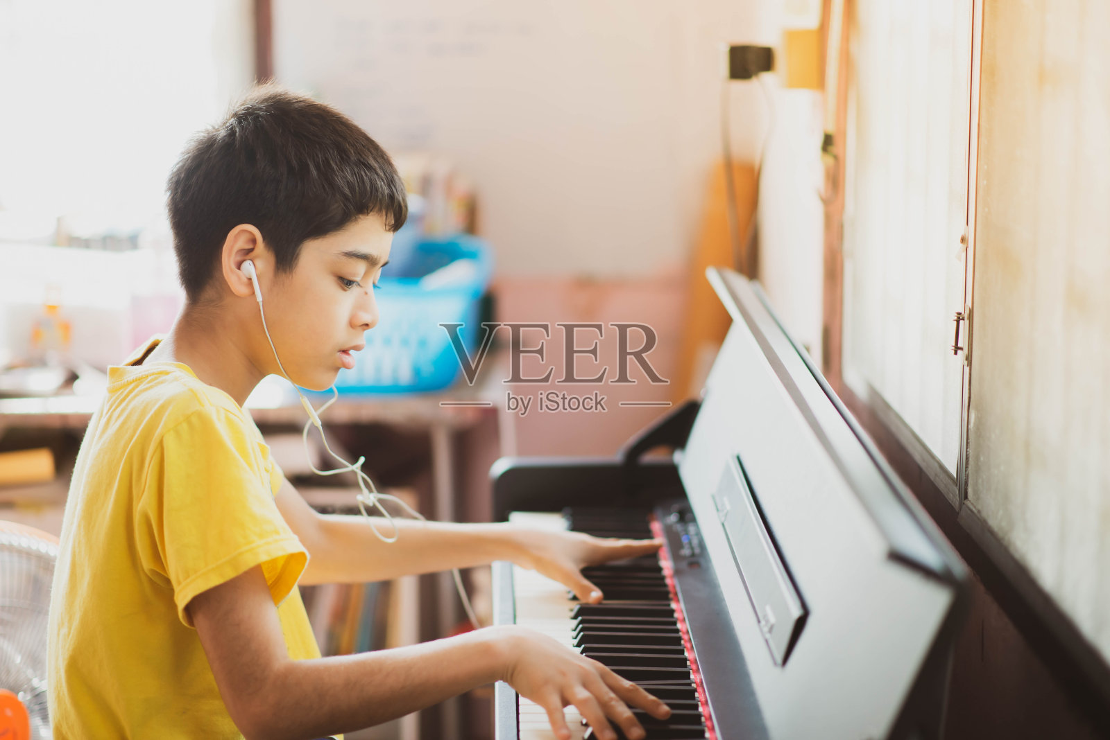 一个小男孩在网上学习练钢琴照片摄影图片