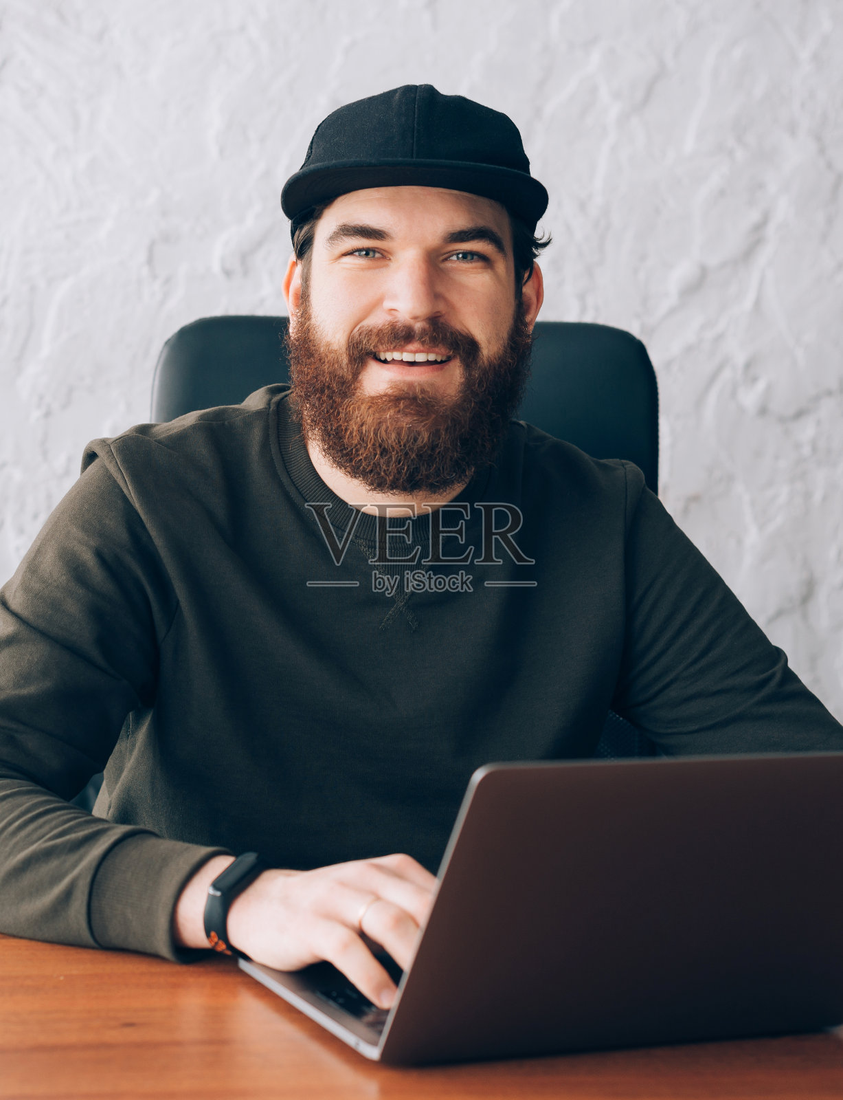 英俊的年轻工人在办公室工作的笔记本电脑的肖像照片摄影图片