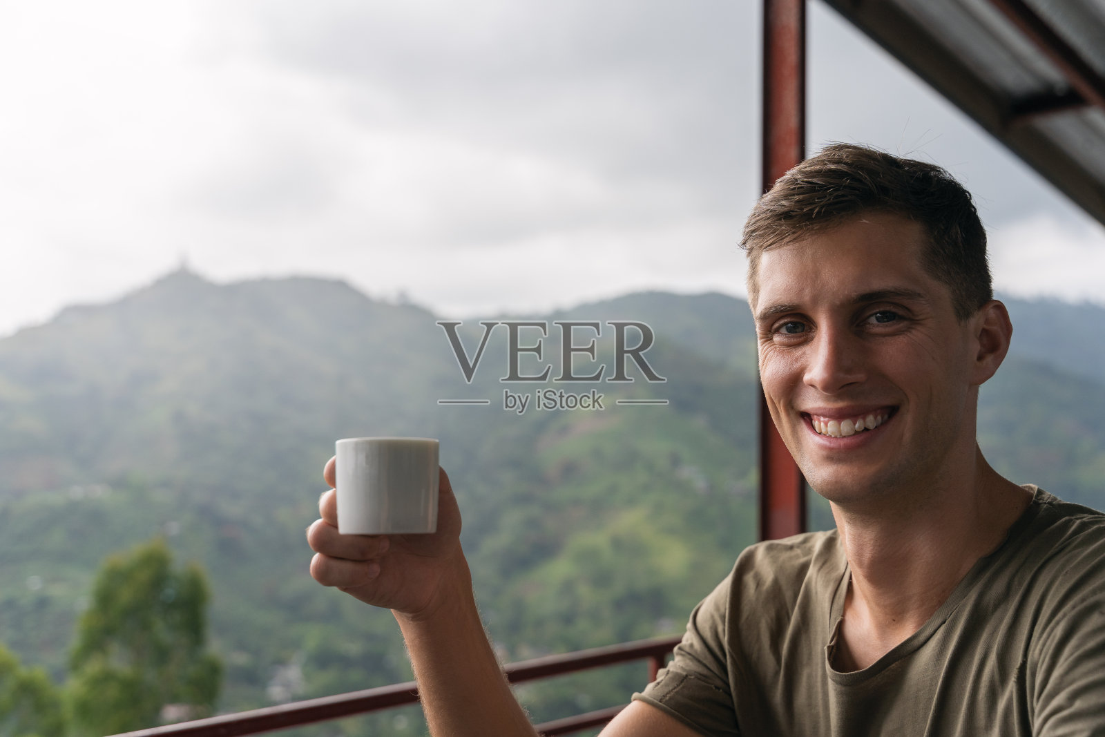 在斯里兰卡的丛林里，年轻英俊的男子品尝着一杯茶照片摄影图片