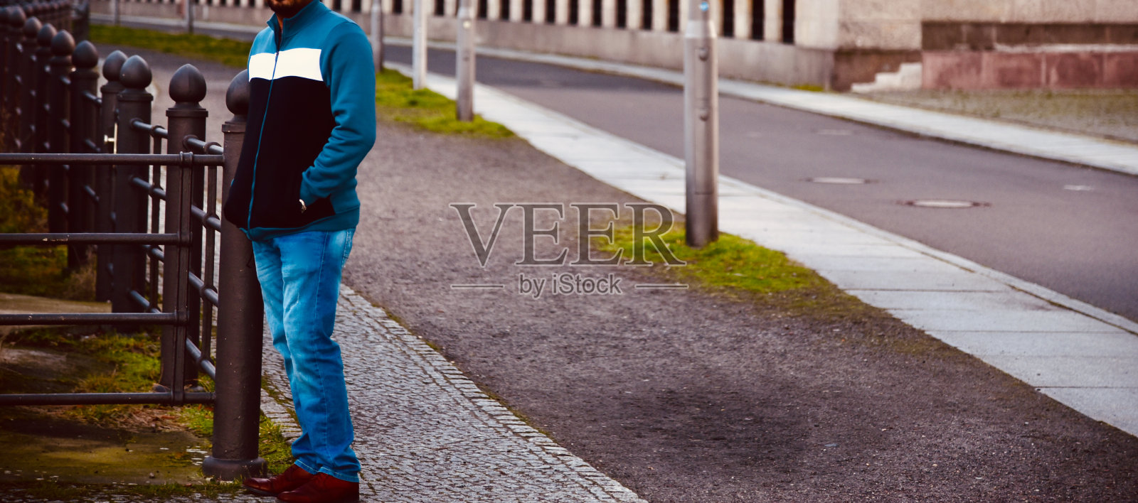 一个穿着蓝色时髦衣服的男人站在柏林的街道旁照片摄影图片