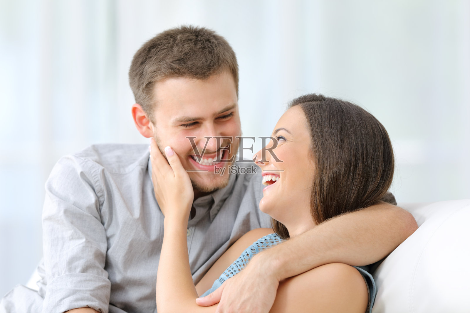 一对幸福的情侣在沙发上谈笑风生照片摄影图片
