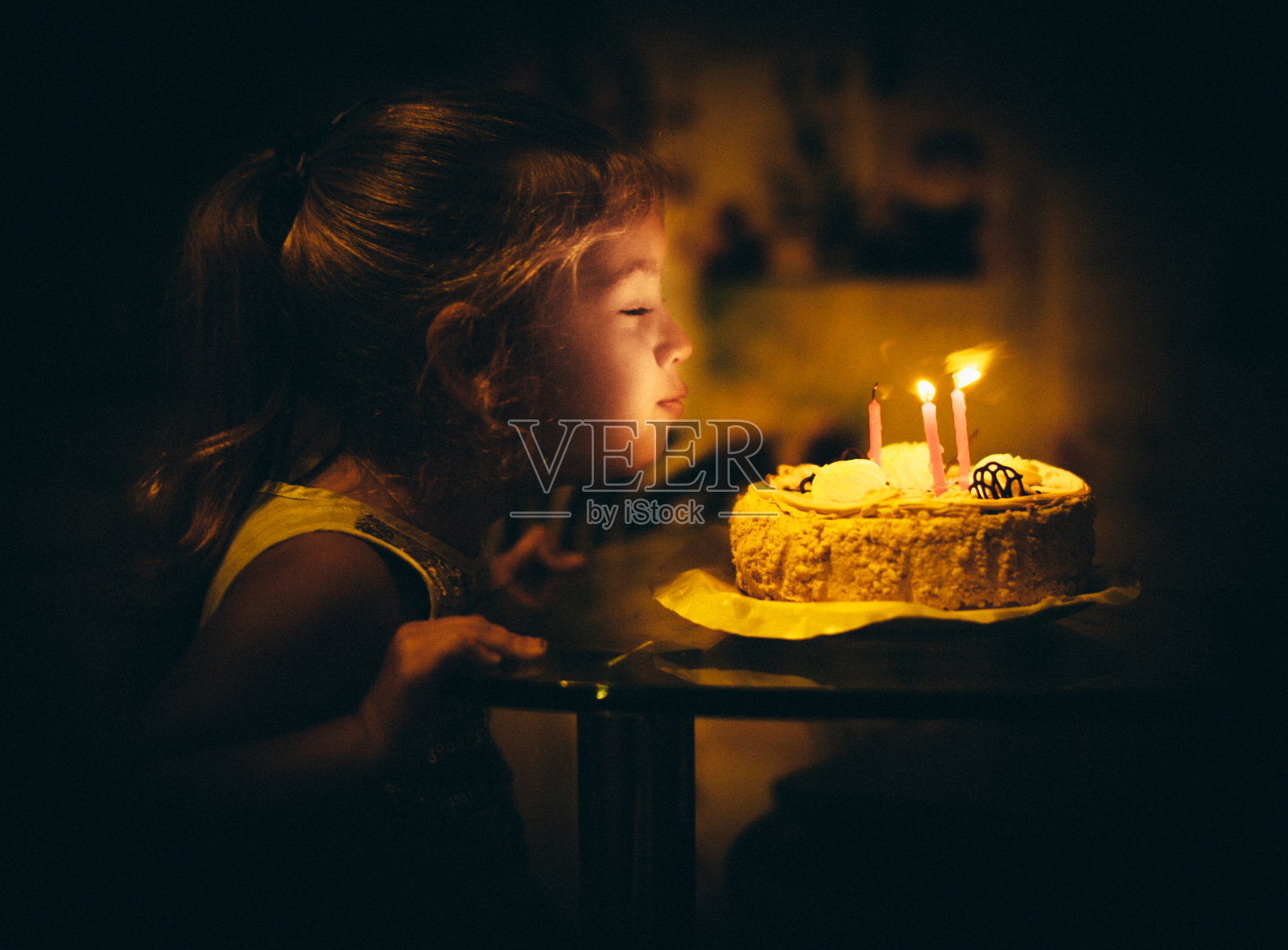 小女孩吹灭蛋糕上的蜡烛，生日快乐照片摄影图片