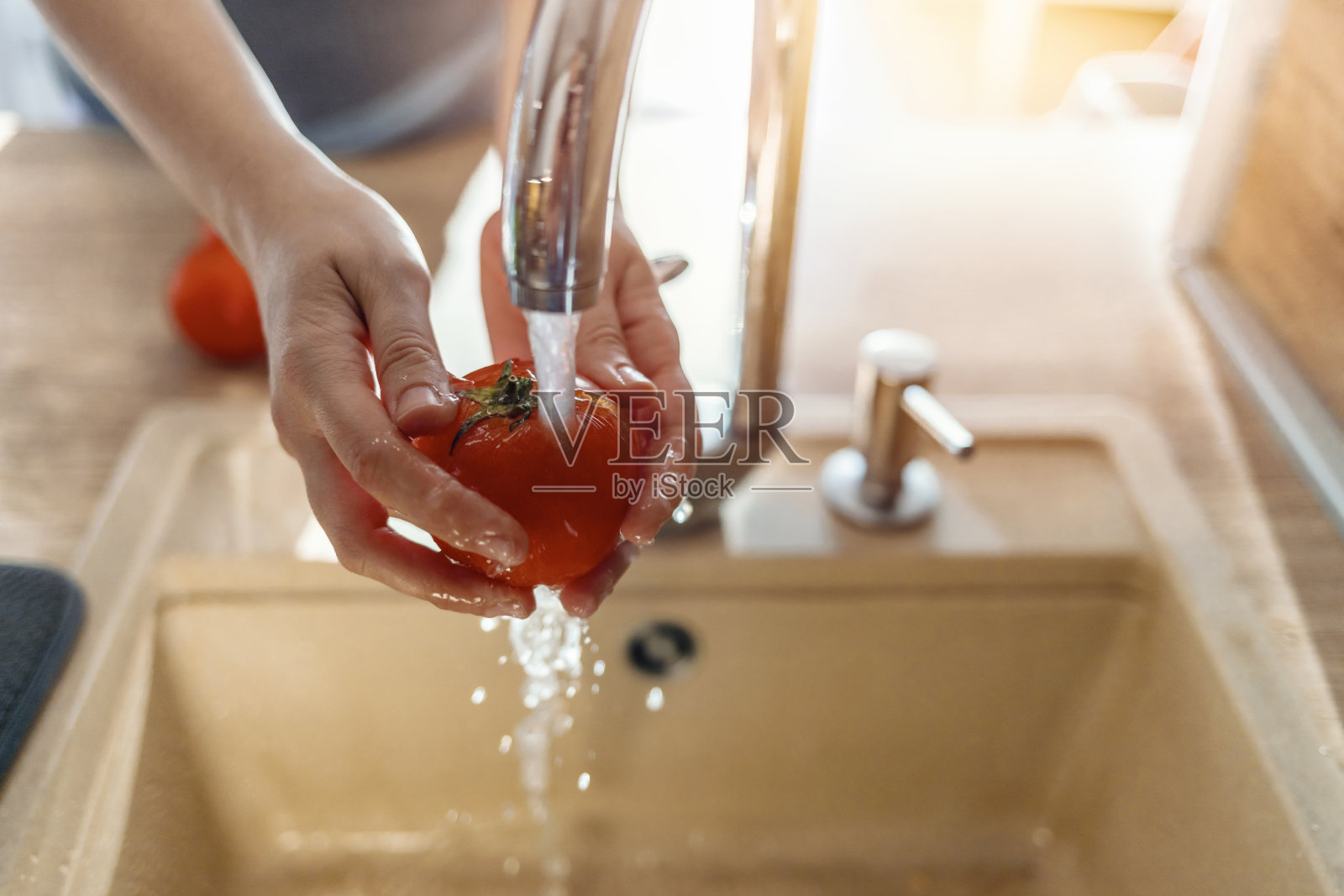 特写的手在流动的水下洗西红柿照片摄影图片